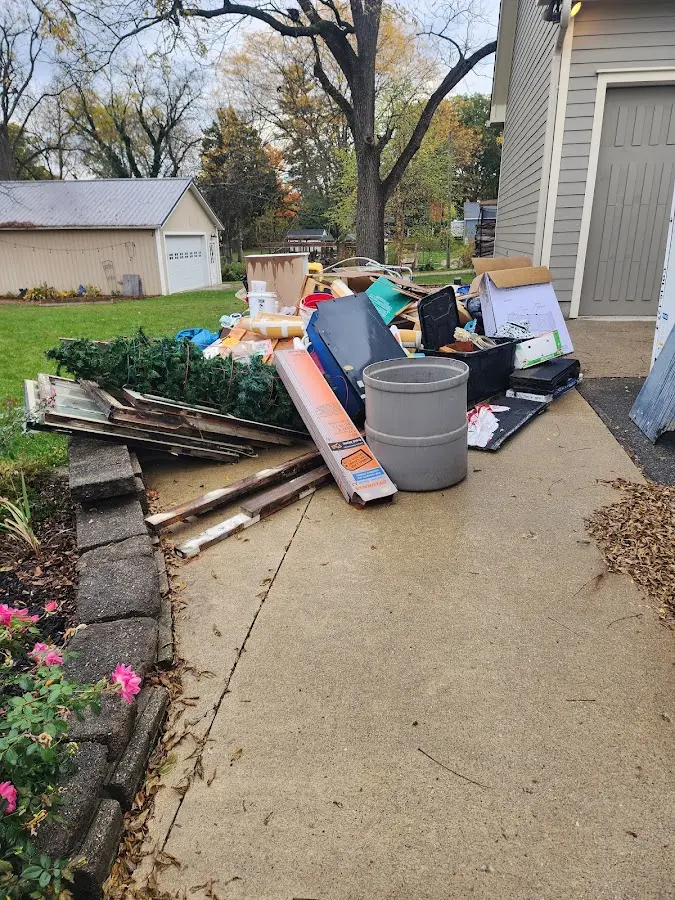 Dumpster being loaded with debris for Estate Cleanout Dumpster Rental in West St. Paul